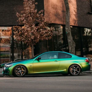 a coupe car wrapped with colour change green car wrap