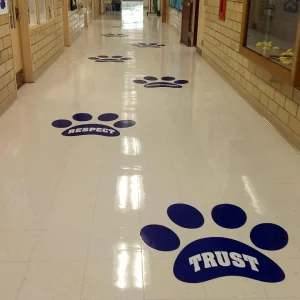 floor decals in the shape of animal paw that say trust, respect and other words on the floor of a school hallway