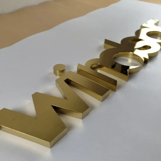 Gold metal letters on white paper
