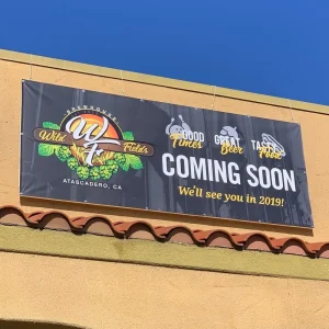 exterior banner installed just below the roof for a restaurant that is opening soon