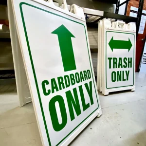 Two plastic sidewalk signs with inserts that say cardboard only and trash only