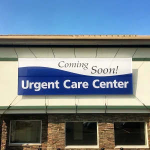 a large banner promoting an urgent car center coming soon