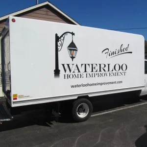 Black cut vinyl lettering and logo on the side of a large delivery truck