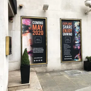 Large printed vinyl posters promoting a show on the side of a building