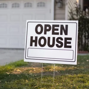 an open house lawn sign installed on grass