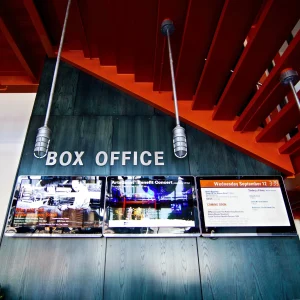 A row of 3 monitors underneath the words "box office".