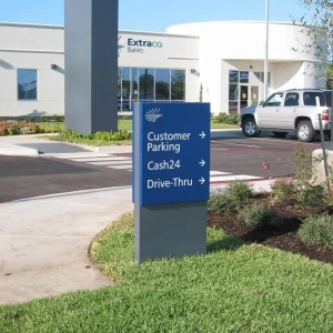 A sign at a bank that shows direction of different locations.