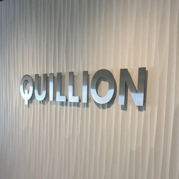 Glossy metal letter sign installed on wall.