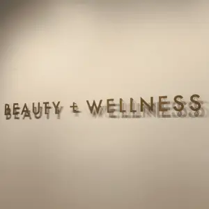 Thin 3D letters that says beauty and wellness installed on interior office wall
