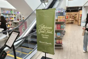 vinyl-banner-sign-4-1.5-L standing banner sign that points to coffees shop upstairs in a large store